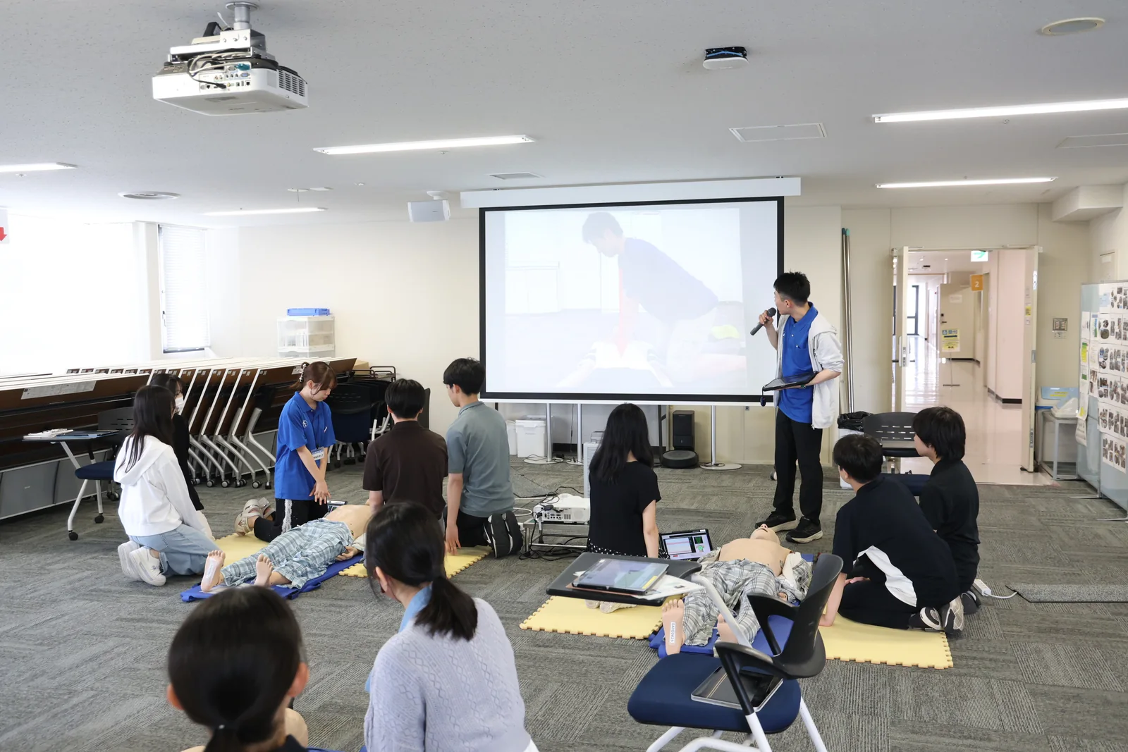 学生スタッフの説明を聞きながら一次救命処置を学ぶ様子