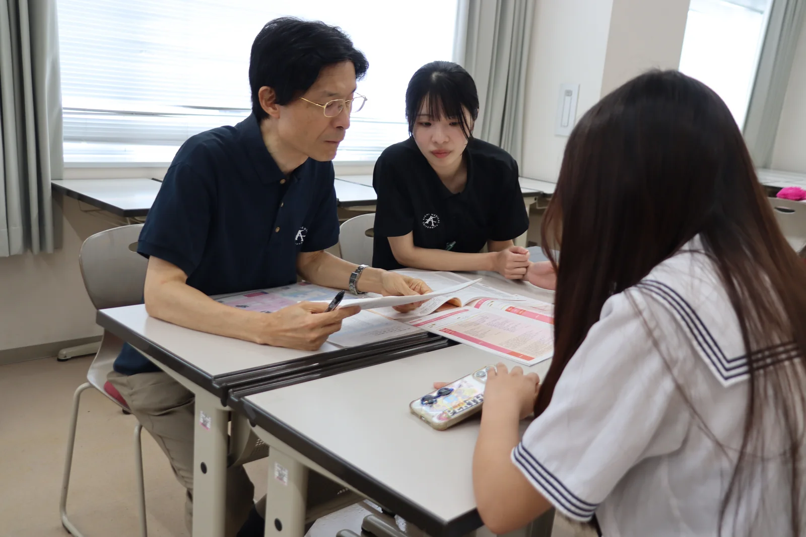 教員が資料を示しながら参加者の質問に答える相談会の様子