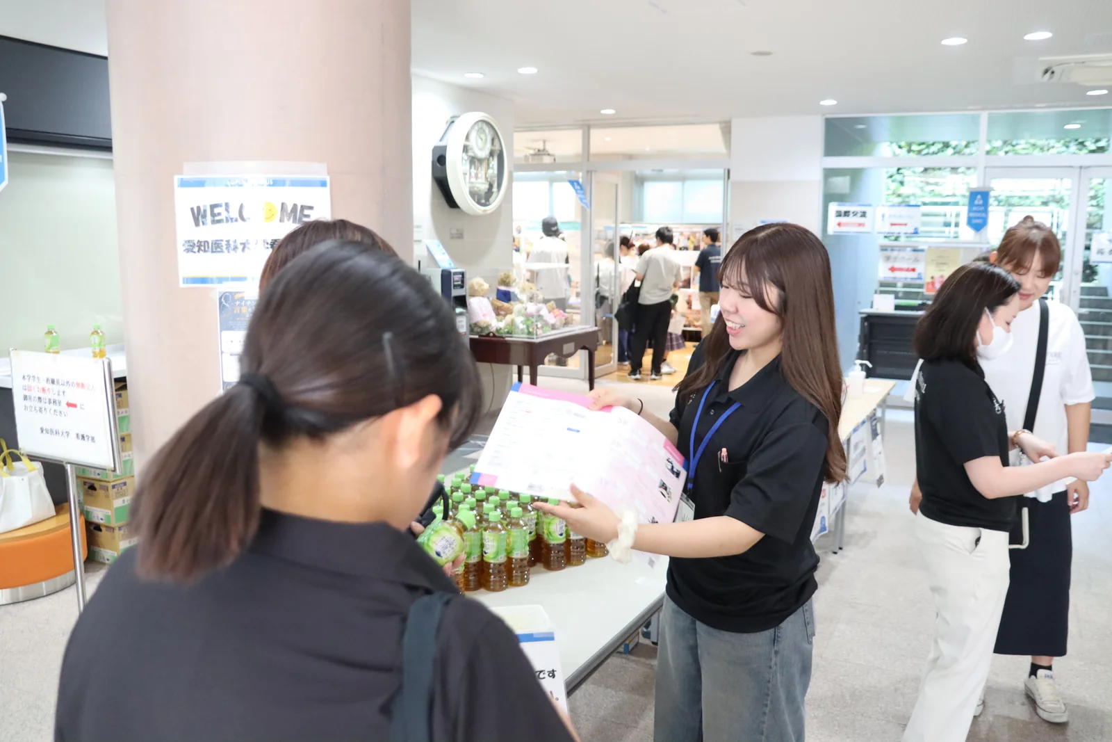 学生スタッフが参加者へ資料を渡す総合受付の様子